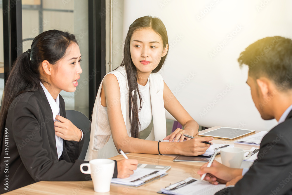 Businesspeople discussing together in conference room during meeting at office Businesspeople discussing together in conference room during meeting at office