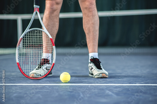 Skillful tennis player standing near equipment