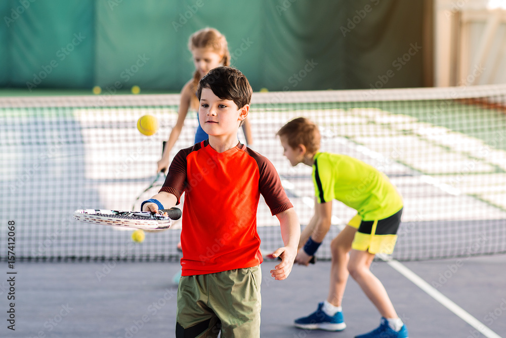 Carefree kids enjoying playtime on tennis court