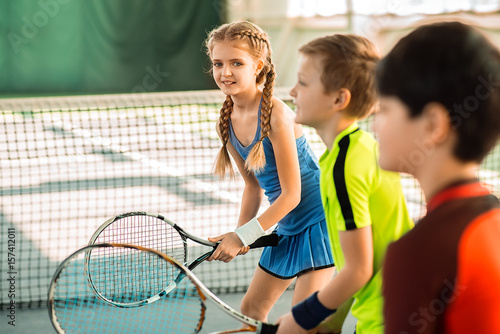 Joyful kids having fun on tennis court