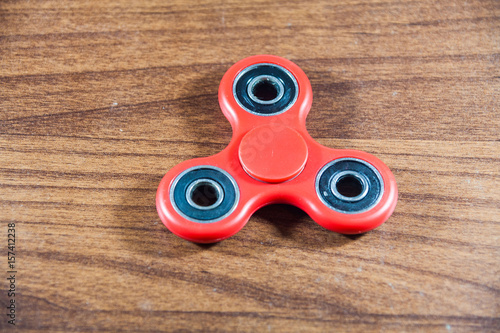 Fidget Spinner in wooden isolated background for stress release during work