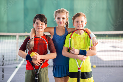 Cheerful kids having fun on tennis court