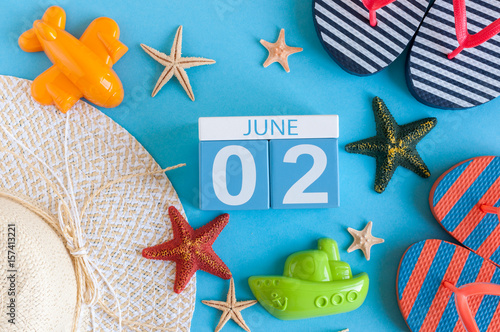 June 2nd. Image of june 2 calendar on blue background with summer beach, traveler outfit and accessories. Summertime concept