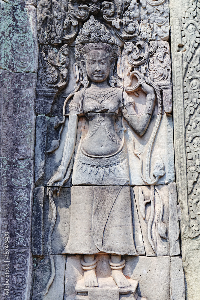 Beautiful Cambodian women dancing Apsaras. Old Khmer art carvings on the wall of Prasat Bayon, the central temple of Angkor Thom Complex, Siem Reap, Cambodia.