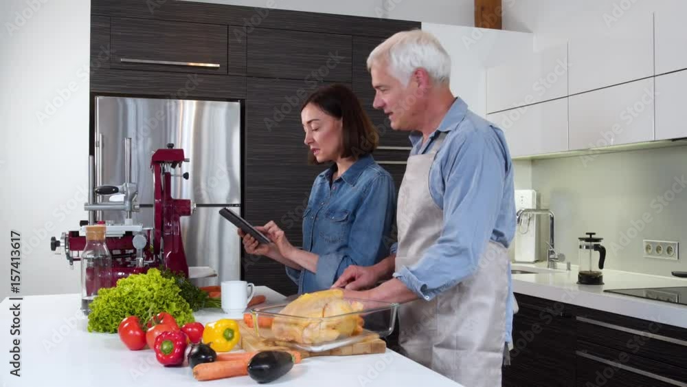 Mature couple cooking meal at home Mature couple cooking meal at home