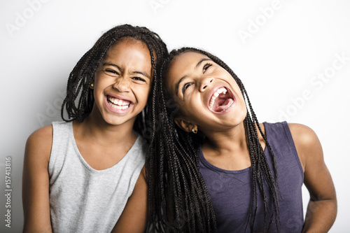 Adorable african twin little girls on studio gray background