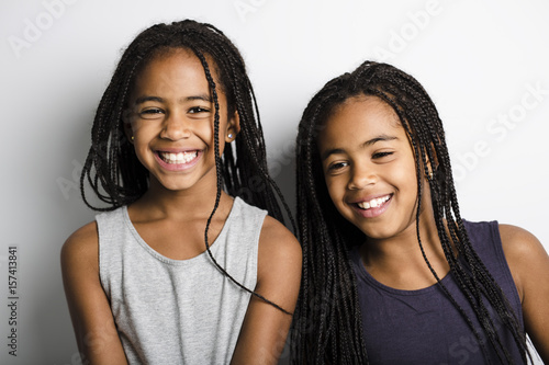 Adorable african twin little girls on studio gray background photo