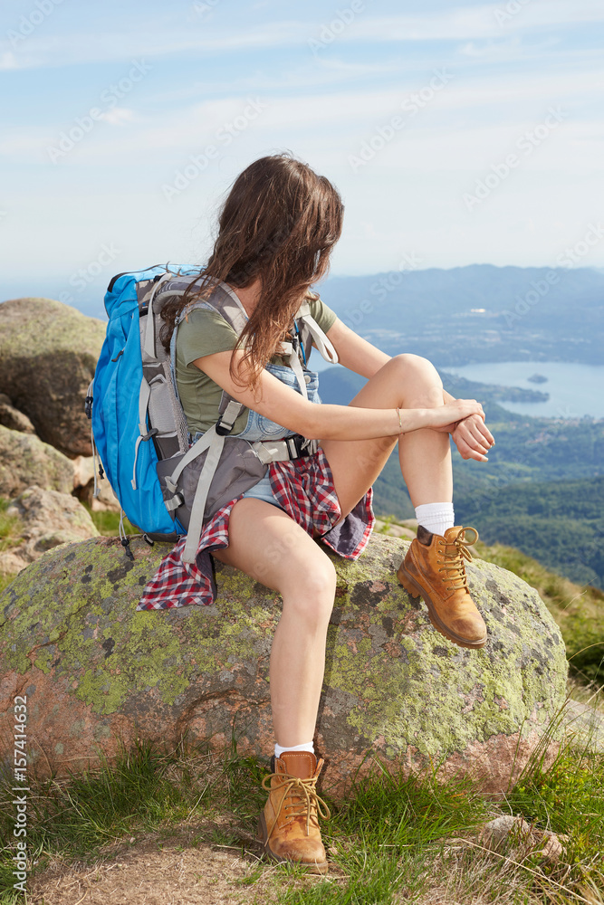 Young woman hiker looking at natural beautiful inspirational landscape Young woman hiker looking at natural beautiful inspirational landscape