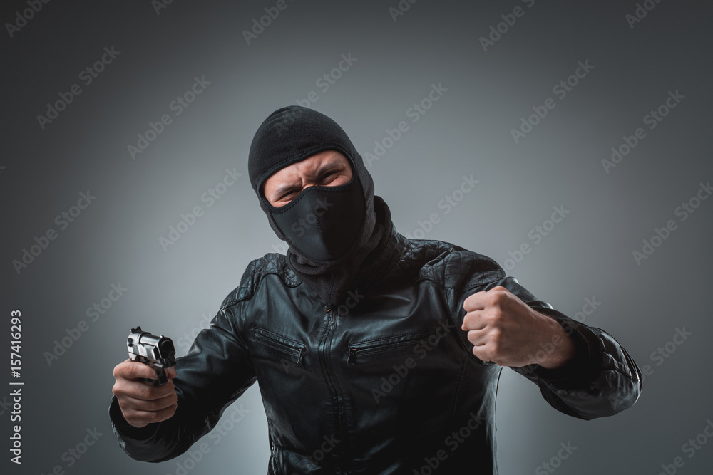 Burglar or terrorist in black mask shooting with gun. Burglar or terrorist in black mask shooting with gun.