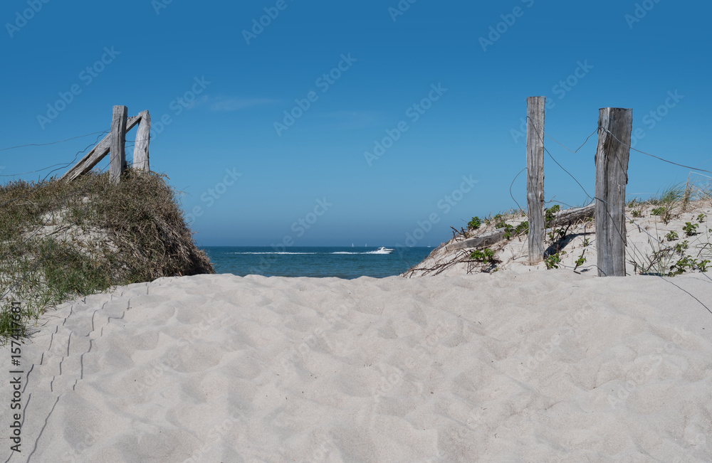 sand path through dunes leading to the baltic sea under clear blue summer sky