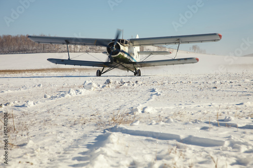 Fototapeta Naklejka Na Ścianę i Meble -  Old plane prepares to take off from a snow-covered field.
