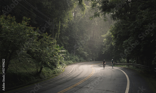 Asian men and woman cyclist are cycling road bike morning uphill on the road
