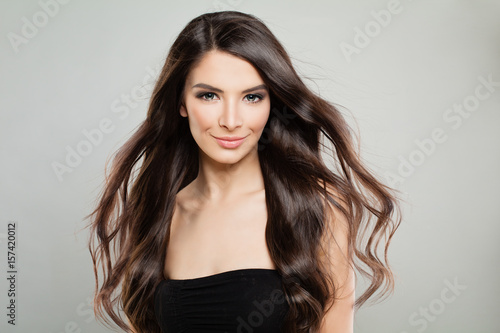 Cheerful Girl with Windy Hair. Fashion Model Woman on Grey Banner Background