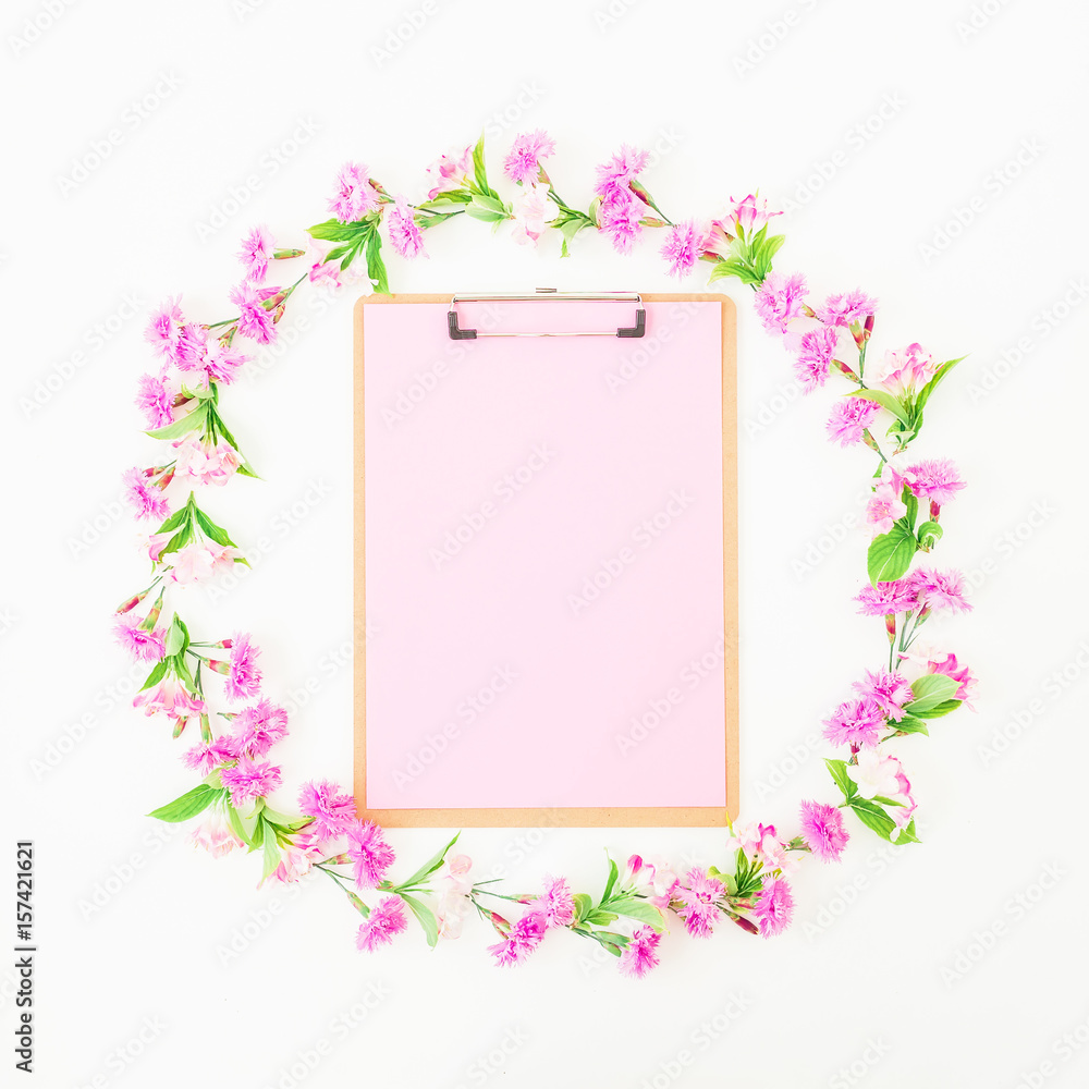 Floral round frame made of pink flowers and clipboard on white background. Flat lay, top view. Floral concept Floral round frame made of pink flowers and clipboard on white background. Flat lay, top view. Floral concept