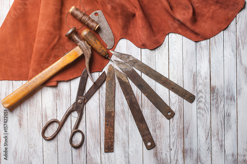 Set of cobbler tools on the light wooden background. Space for text. photo