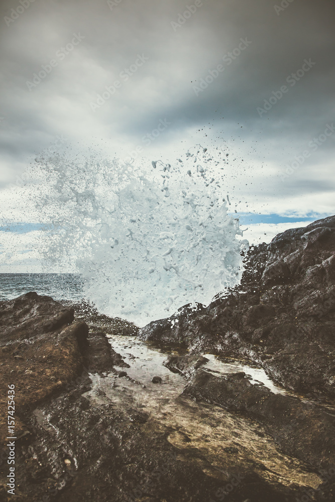 Obraz premium Waves crashing or rocks in hawaii