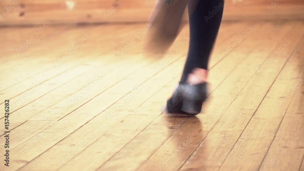 Closeup of black shoes dancing on the wooden floor Closeup of black shoes dancing on the wooden floor