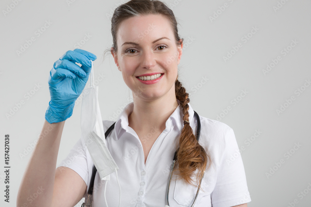 Junge Ärztin zeigt Hygiene Mundschutz Junge Ärztin zeigt Hygiene Mundschutz