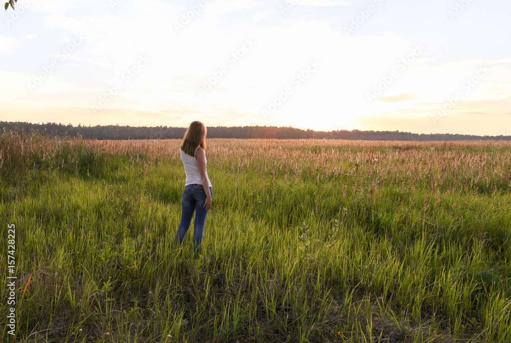 Beautiful blondie lady in field at sunset, feels happy.