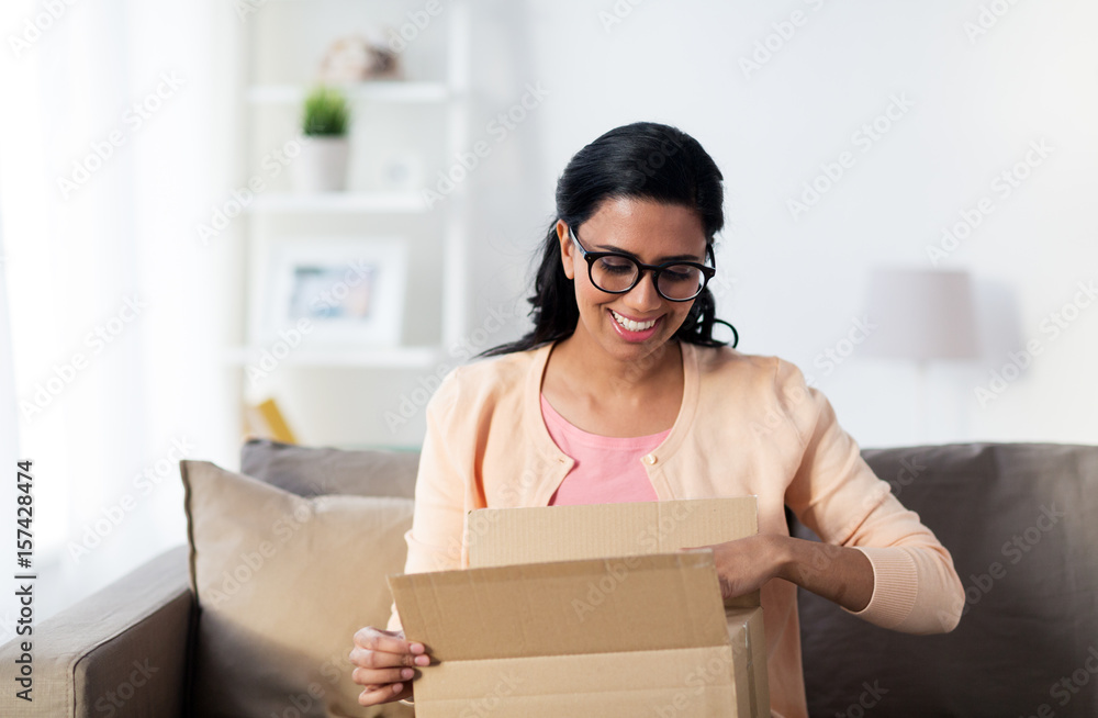 happy young indian woman with parcel box at home happy young indian woman with parcel box at home