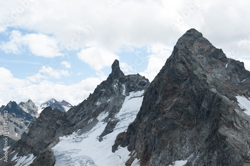 Zwei felsige Berggipfel mit Gletscher.