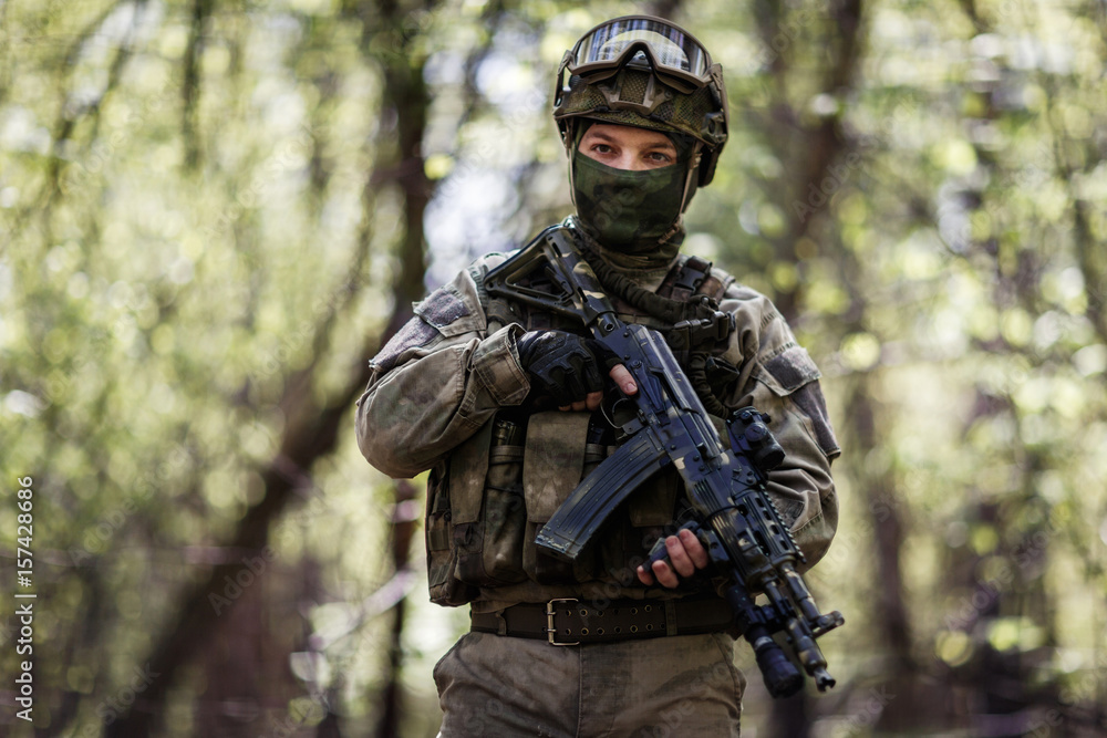 Soldier in helmet patrols forest