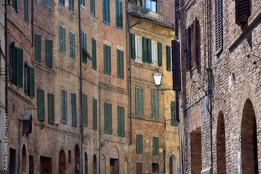Naklejka premium Cityscape - Siena, Tuscany, Italy. Background of typical city architecture, parts of buildings, Shutters, arches and windows.
