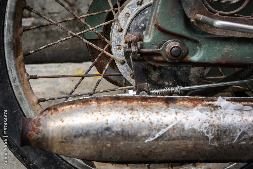 rear wheel and rusty exhaust of a vintage motorbike grungy style
