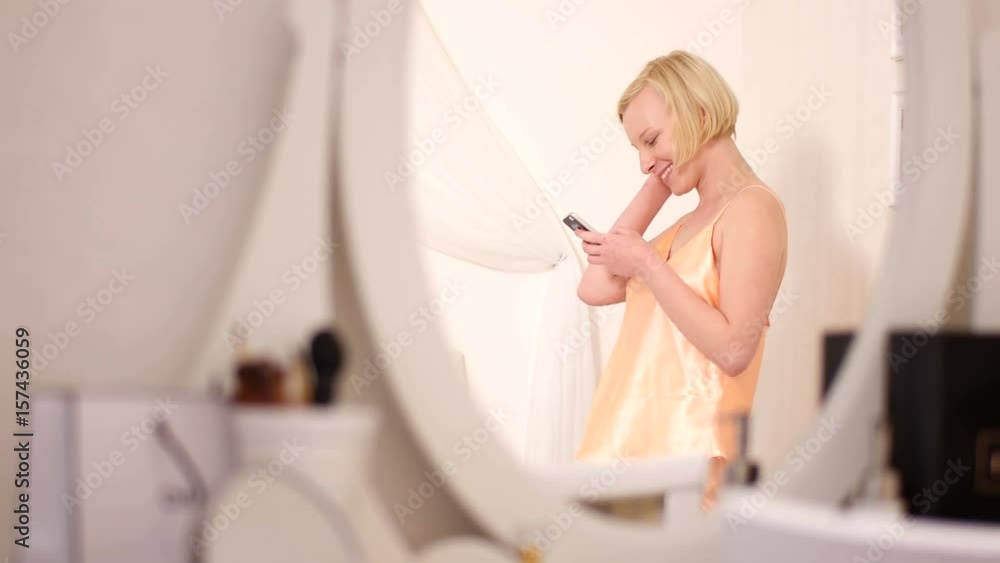 Reflection in the mirror of a woman who reads sms Reflection in the mirror of a woman who reads sms
