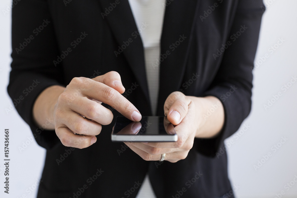 close up view of business woman hands typing on her smart phone. Indoors. lifestyles. white backgrounds. close up view of business woman hands typing on her smart phone. Indoors. lifestyles. white backgrounds.