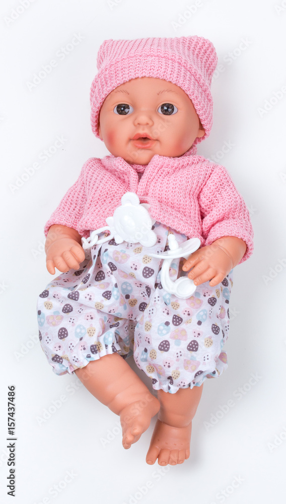Toy doll child, in pink blouse with pacifier on isolated background Toy doll child, in pink blouse with pacifier on isolated background