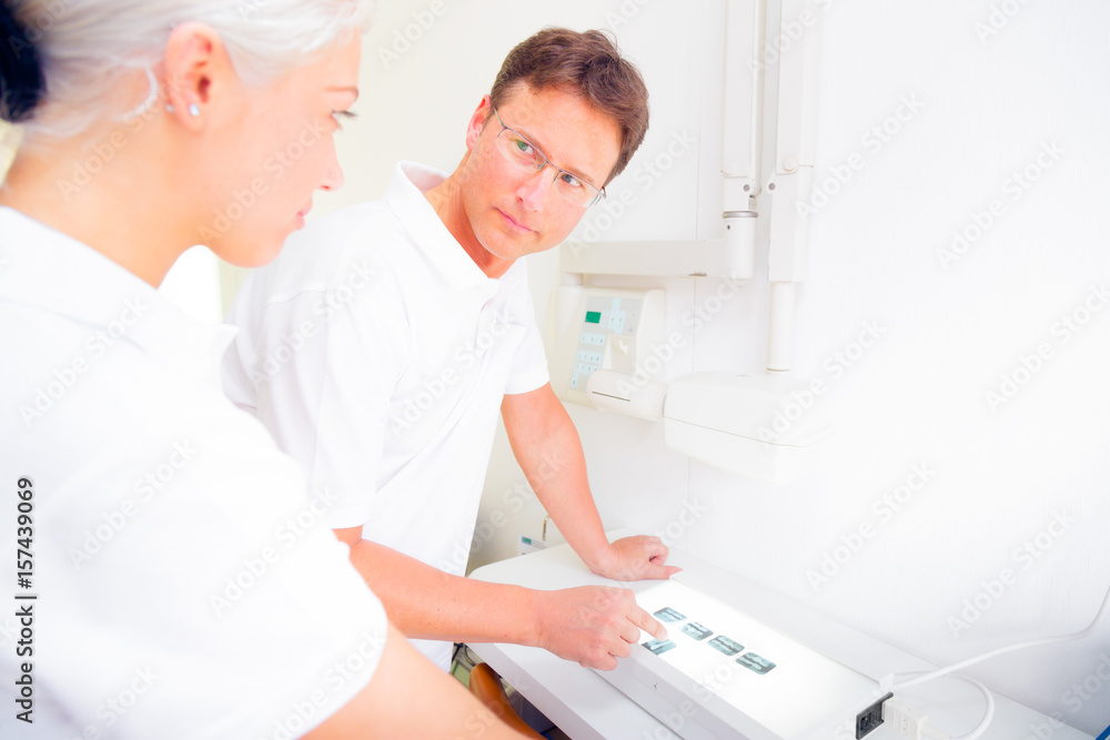 Dentist And Assistant Looking At Dental X-ray Dentist And Assistant Looking At Dental X-ray