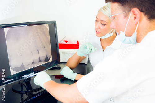 Dentist And Assistant Looking At Dental X-ray