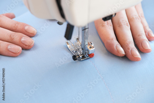 Seamstress threading fabrics on sewing machine