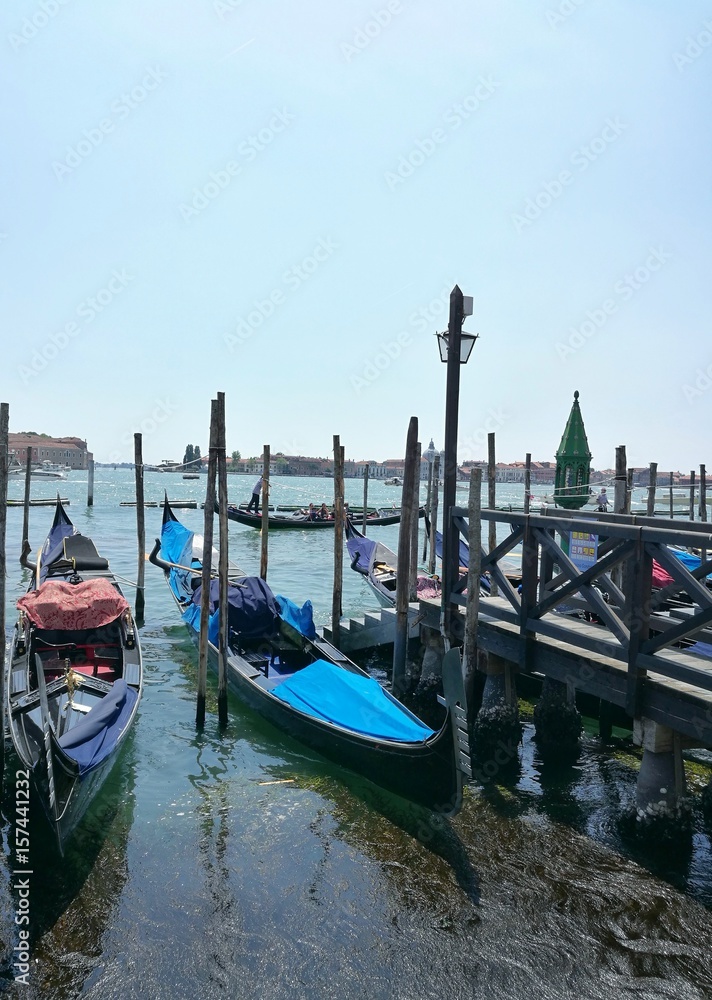 VENICE, ITALY - MAY 18, 2017 : scenic view of gondola in harbor of Venice city during a sunny day