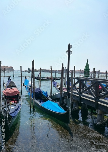 VENICE, ITALY - MAY 18, 2017 : scenic view of gondola in harbor of Venice city during a sunny day photo