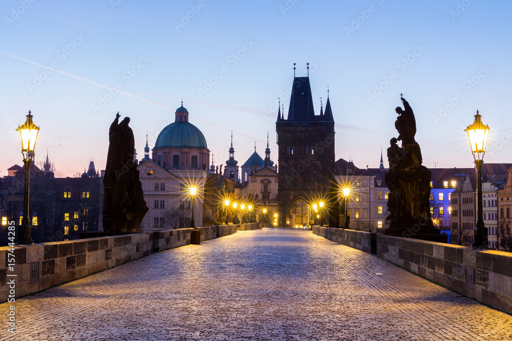 Prague, Czech Republic. Charles Bridge with its statuette and sunrise over the bridge, Old Town Bridge Tower in the background.