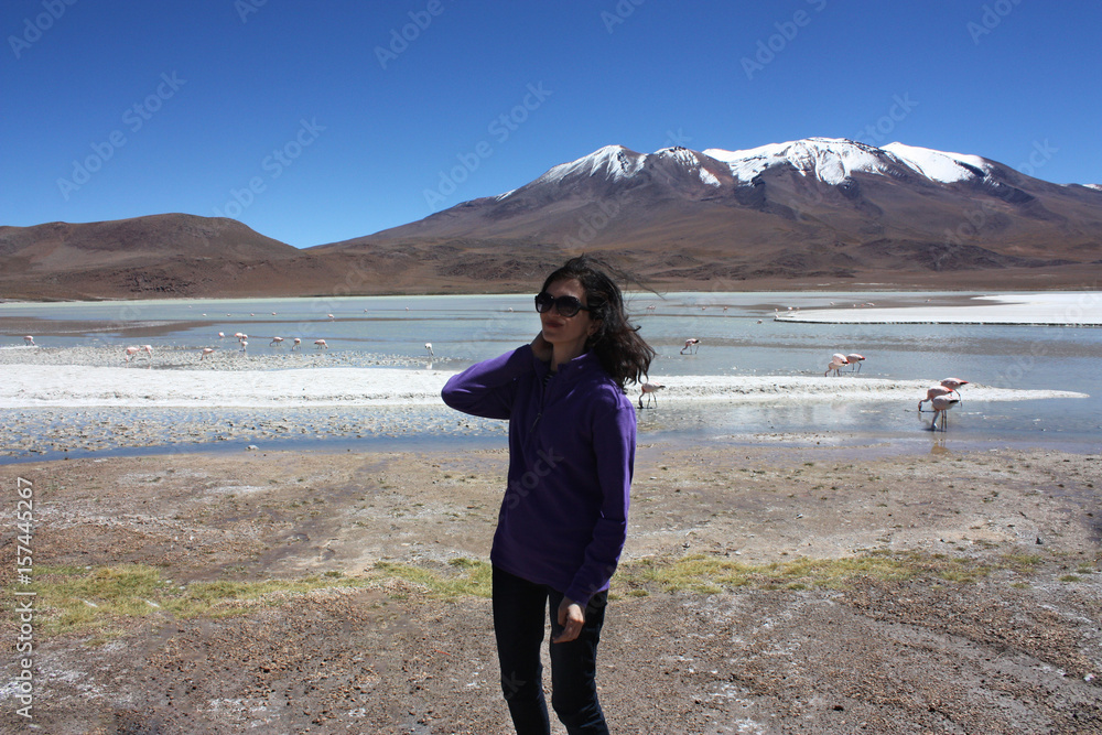 mid age smiling woman and Wild flamingos in lagoon, Bolivia