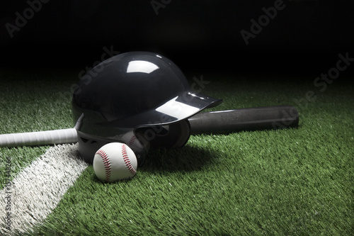 Baseball batting helmet bat and ball on field with stripe and dark background