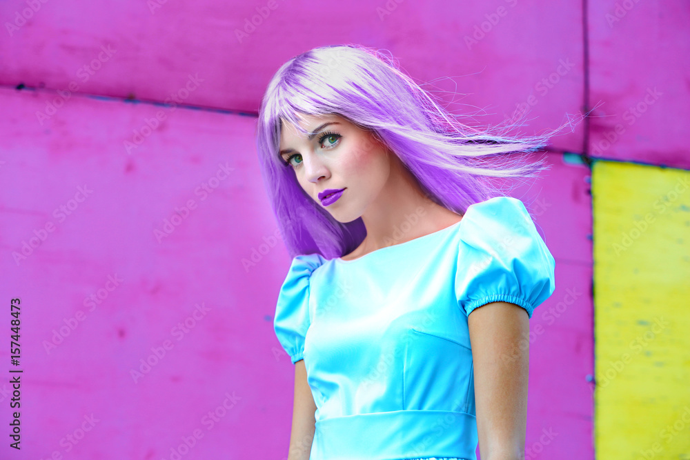 Portrait of beautiful woman with pink hairstyle on bright wall background Portrait of beautiful woman with pink hairstyle on bright wall background
