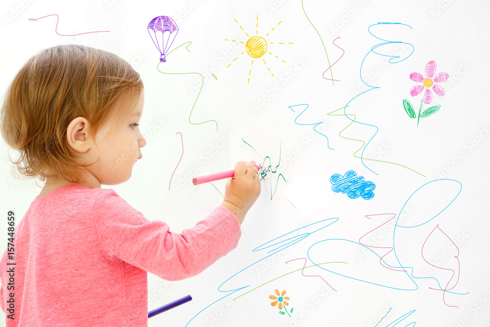 Obraz premium Cute little girl drawing on light wall