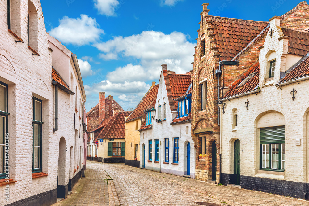 Vintage street in Bruges Belgium with blue sky and white cloud.