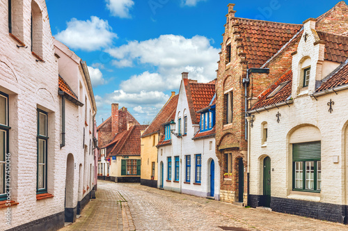 Vintage street in Bruges Belgium with blue sky and white cloud.