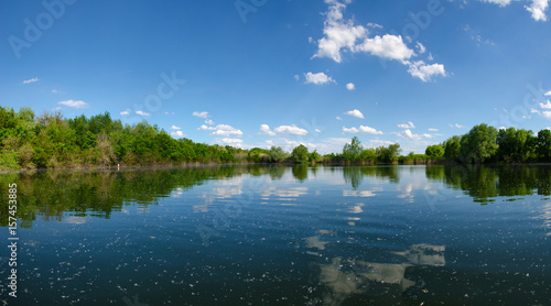 Fototapeta Naklejka Na Ścianę i Meble -  Panorama landscape. Beautiful summer lake with cloudy sky background. Water mirror with poplar fluff.