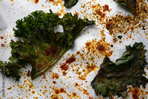 Crispy chili kale chips, herbs, on baking tray. Close-up image
