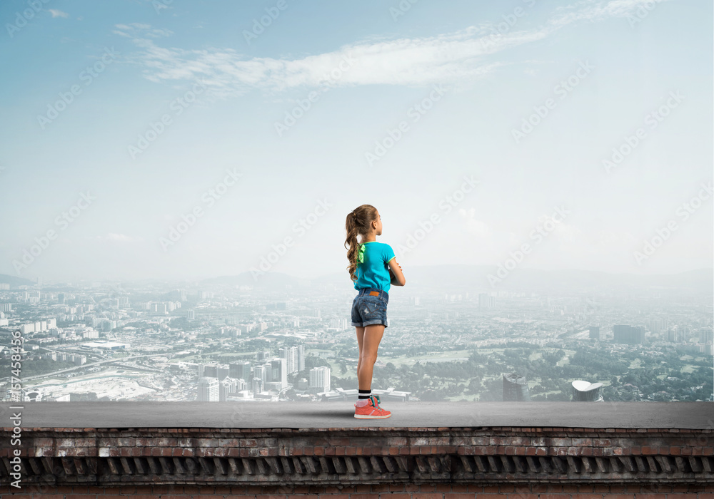 Concept of careless happy childhood with girl looking far away Concept of careless happy childhood with girl looking far away