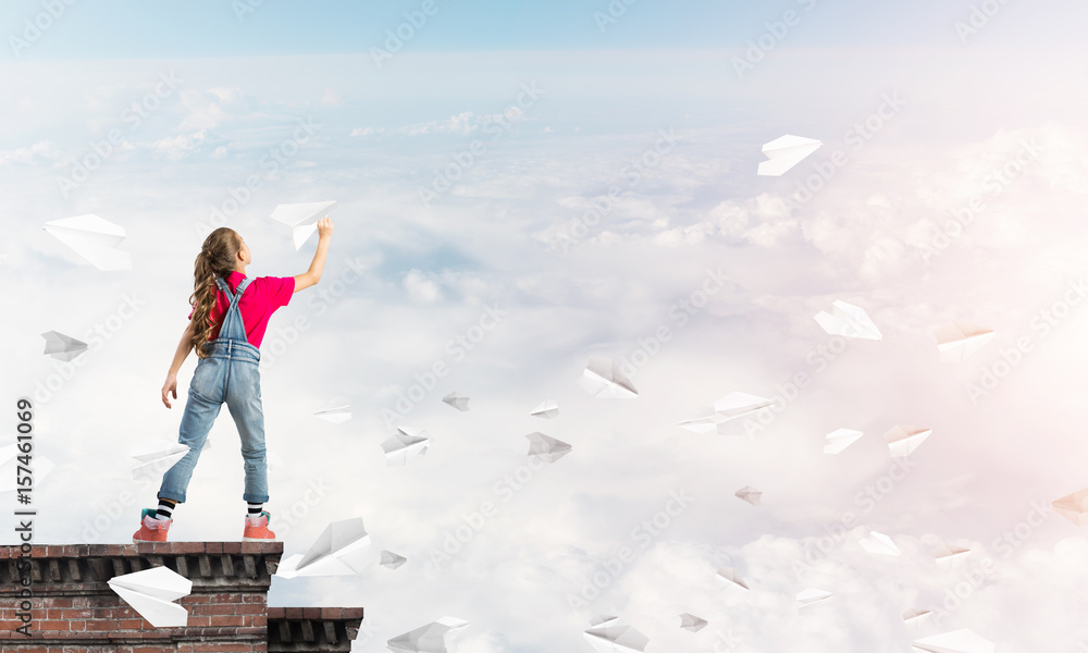 Concept of careless happy childhood with girl dreaming to become pilot Concept of careless happy childhood with girl dreaming to become pilot