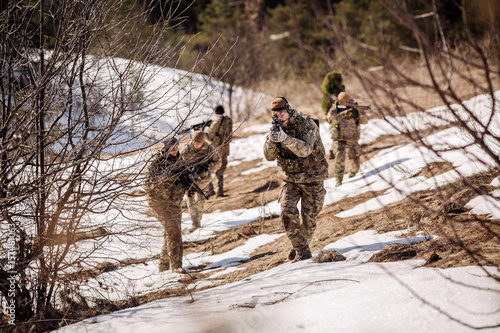 team of special forces weapons in cold forest. Winter warfare and military concept