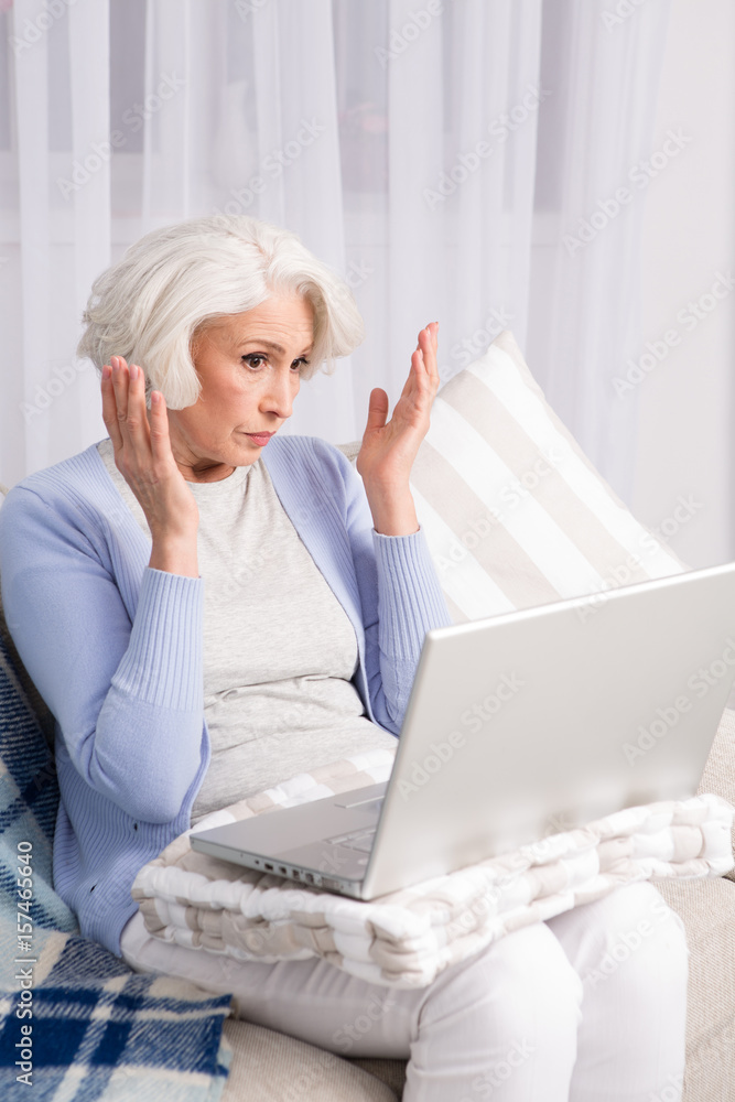 Elderly woman communicating in social network. Pretty woman using laptop computer while staying at home. Computer technologies concept. Elderly woman communicating in social network. Pretty woman using laptop computer while staying at home. Computer technologies concept.