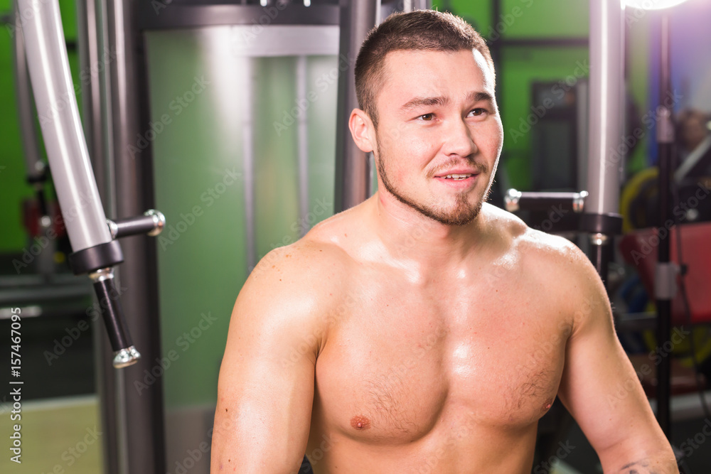 handsome fitness man weightlifting after workout in gym handsome fitness man weightlifting after workout in gym